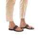 Model wearing Aja brown, handmade leather slide sandals with toe loop 