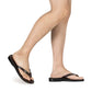 Model wearing Jaffa brown, slip-on flip flop style leather sandal - side view