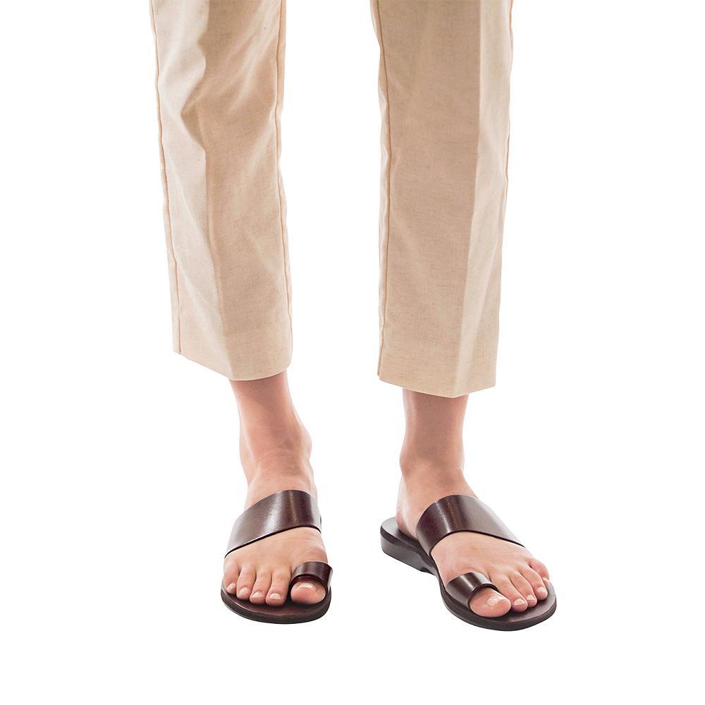 Model wearing Abra brown, handmade leather slide sandals with toe loop 