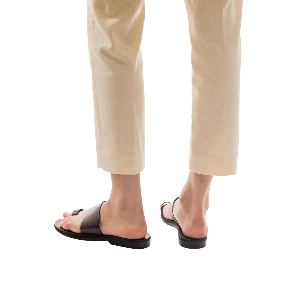Model wearing Abra brown, handmade leather slide sandals with toe loop 