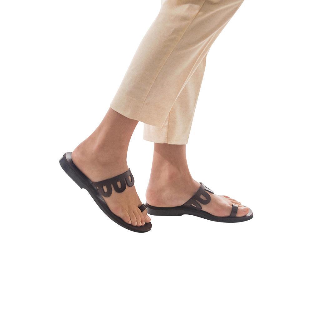 Model wearing Aja brown, handmade leather slide sandals with toe loop 