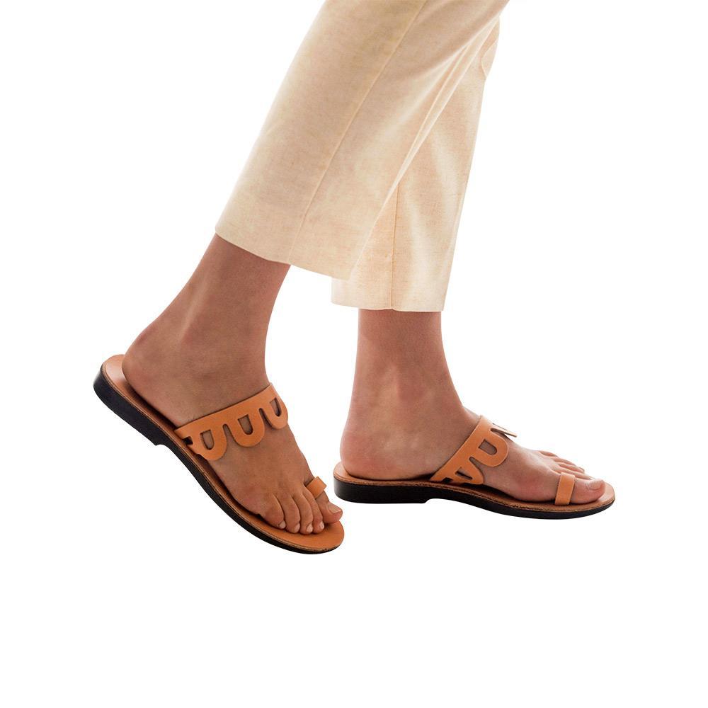 Model wearing Aja tan, handmade leather slide sandals with toe loop 