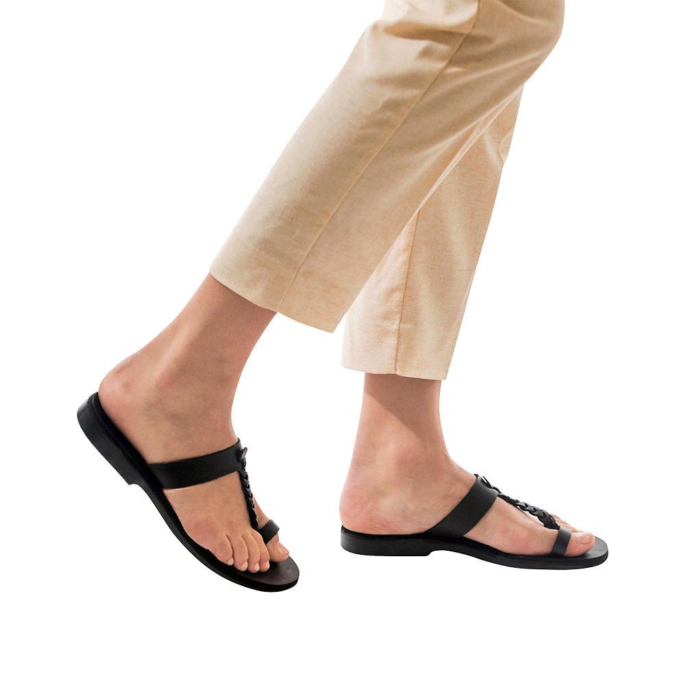 Model wearing Ara black, handmade leather slide sandals with toe loop 