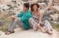 a male and female models sitting o a rock wearing Jerusalem sandals